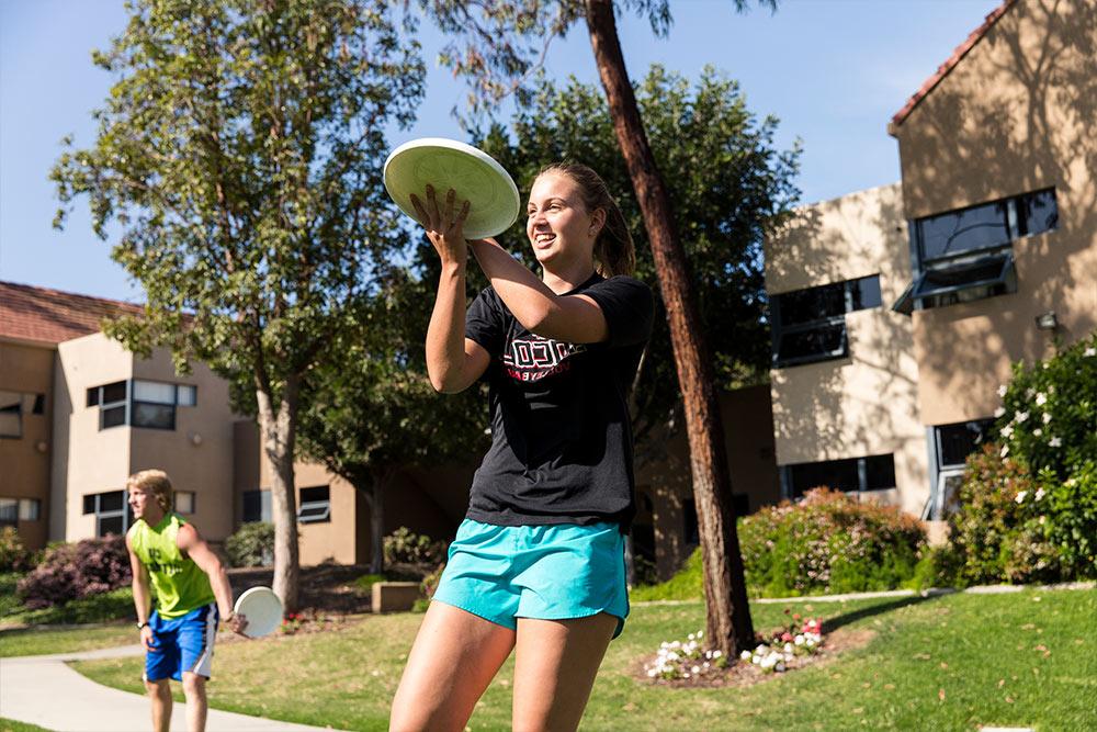 Practicing a two-hand catch as students warm-up for ultimate frisbee